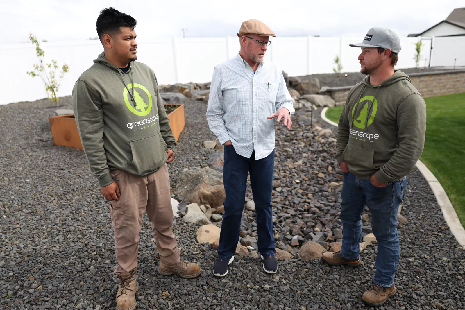 Greenscape crew members talking with a Spokane homeowner