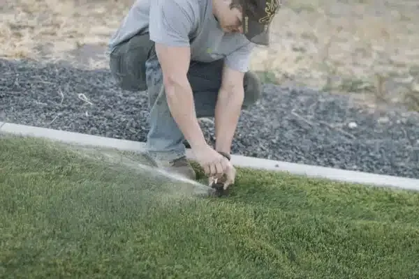Greenscape Landscaping Tech fixing a broken sprinkler