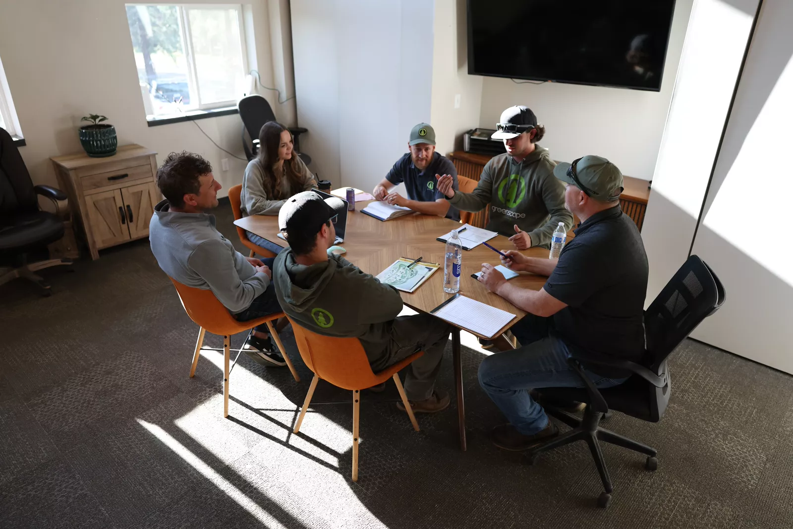 Greenscape Landscaping team meeting around the office table