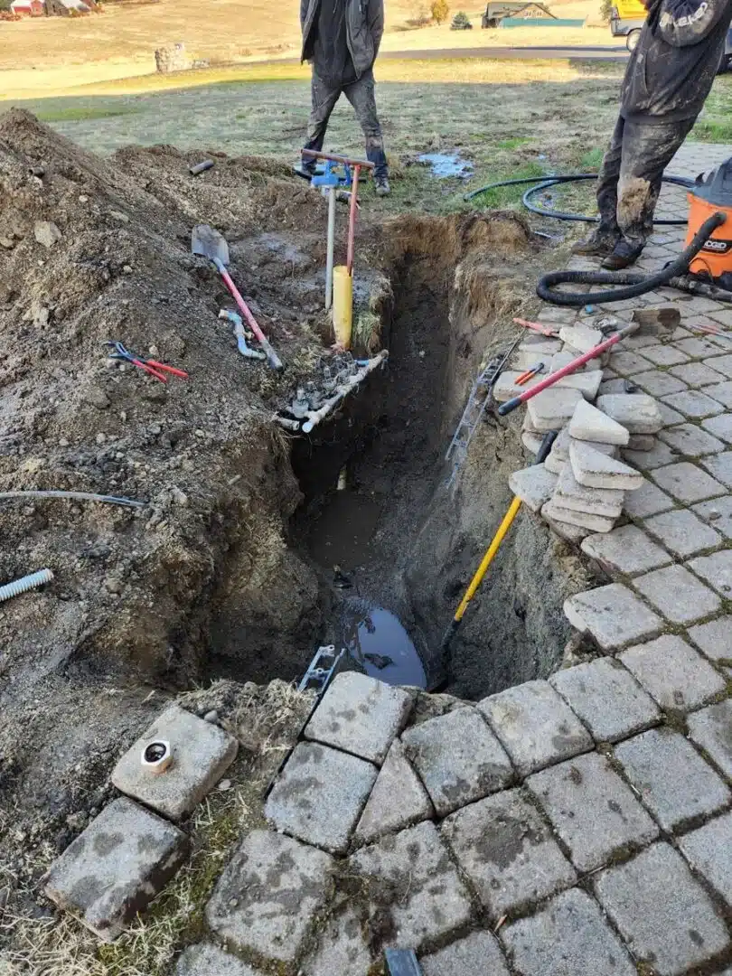 Greenscape Landscaping of Spokane technicians performing a sprinkler repair by digging to access damaged underground irrigation lines.