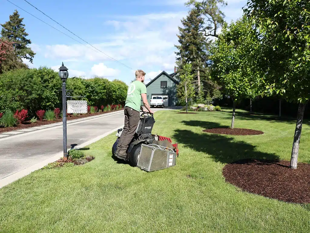Greenscape employee is mowing a customers lawn in Spokane Washington