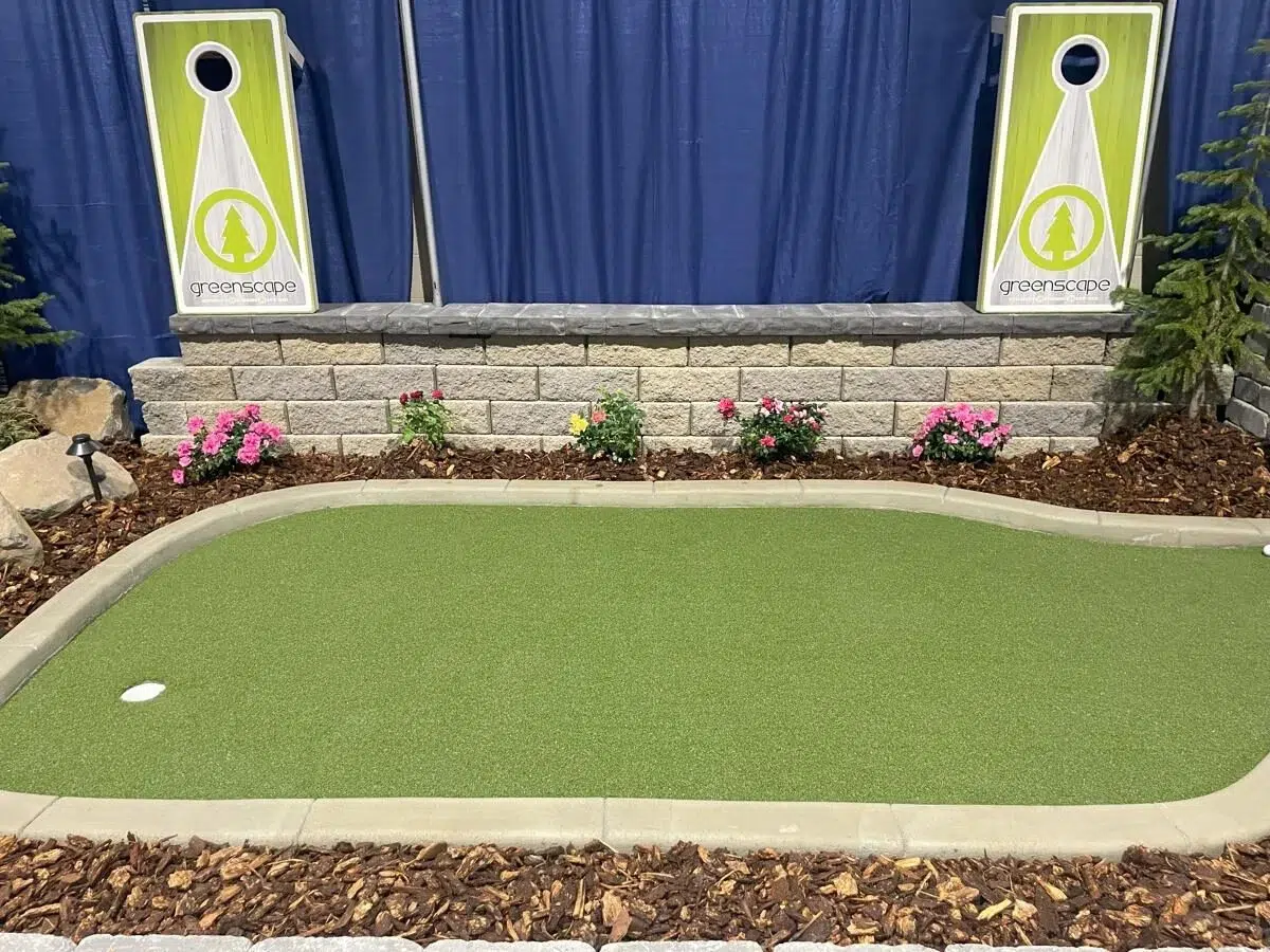 Indoor display of completed artificial grass installation for a putting green.