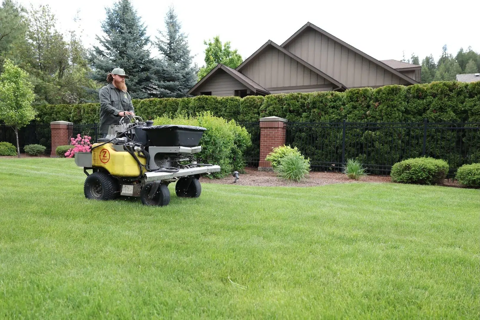 Greenscape Landscaping employee spreading an organic soil builder to strengthen a lawn