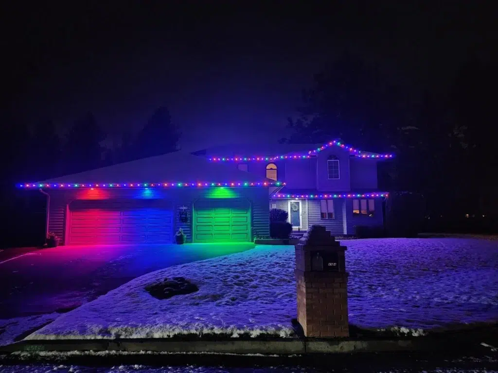 Bright red, green, and blue LED Christmas lights illuminating a Spokane home installed by Greenscape Landscaping.